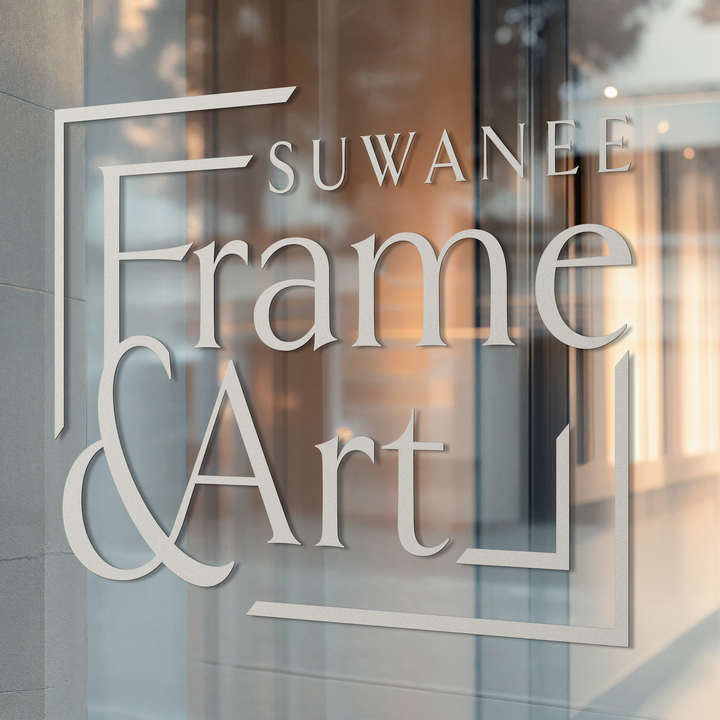 Glass door with 'Suwanee Frame & Art' logo on a building facade.