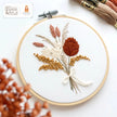 Flowers Bouquet embroidery hoop with a dried-flower bouquet in terracotta, blush and gold tied with a white bow