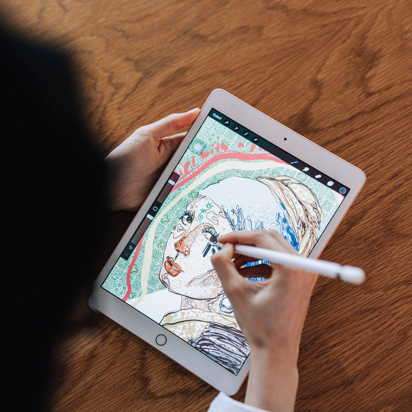 Artist drawing a portrait illustration in Procreate on an iPad with a stylus