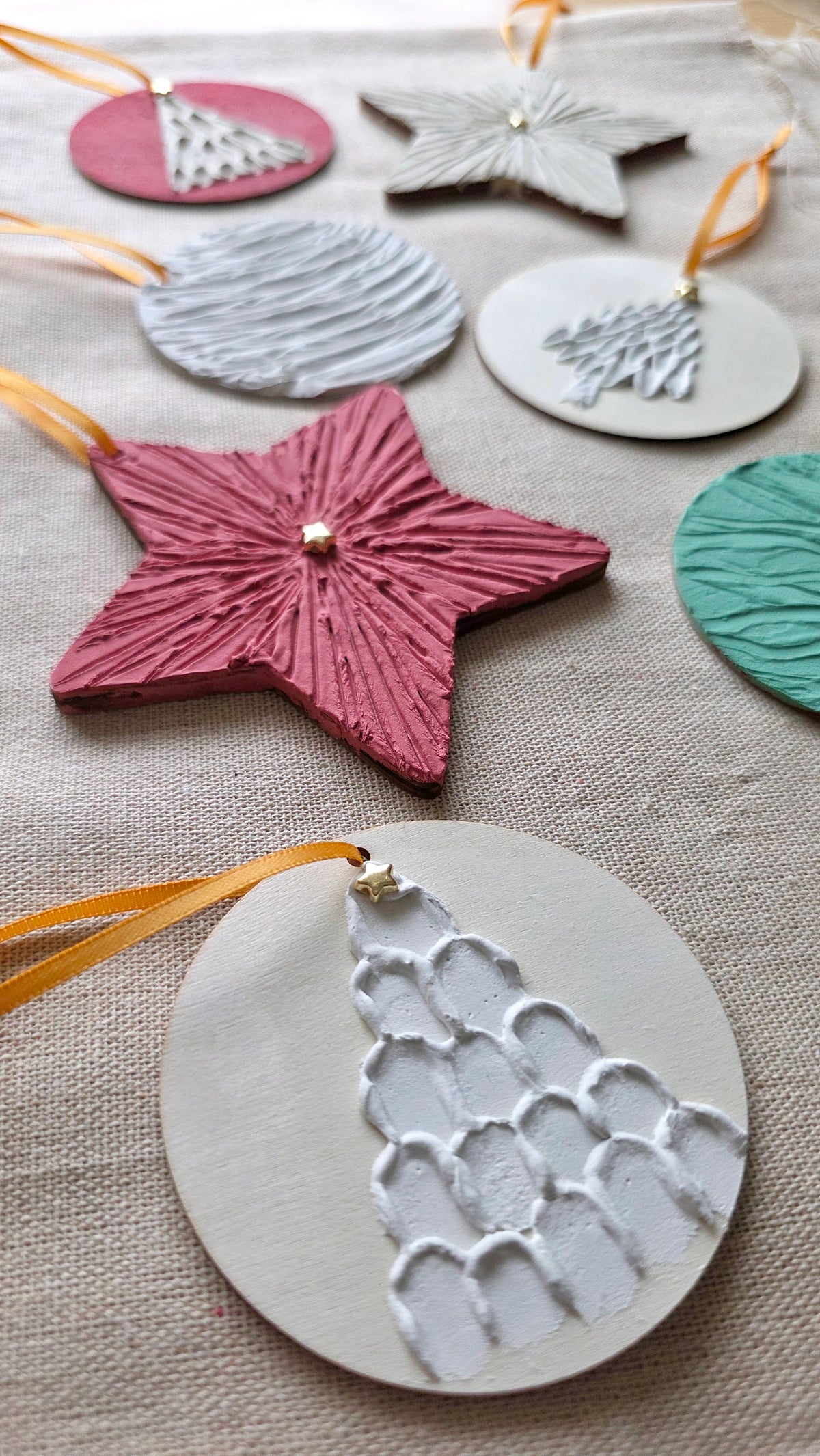 Close-up of a pink textured plaster star ornament with a small gold star center