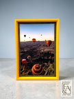 Suwanee Frame & Art hot air balloon landscape print in a bright yellow frame, depicting Cappadocia at sunrise.
