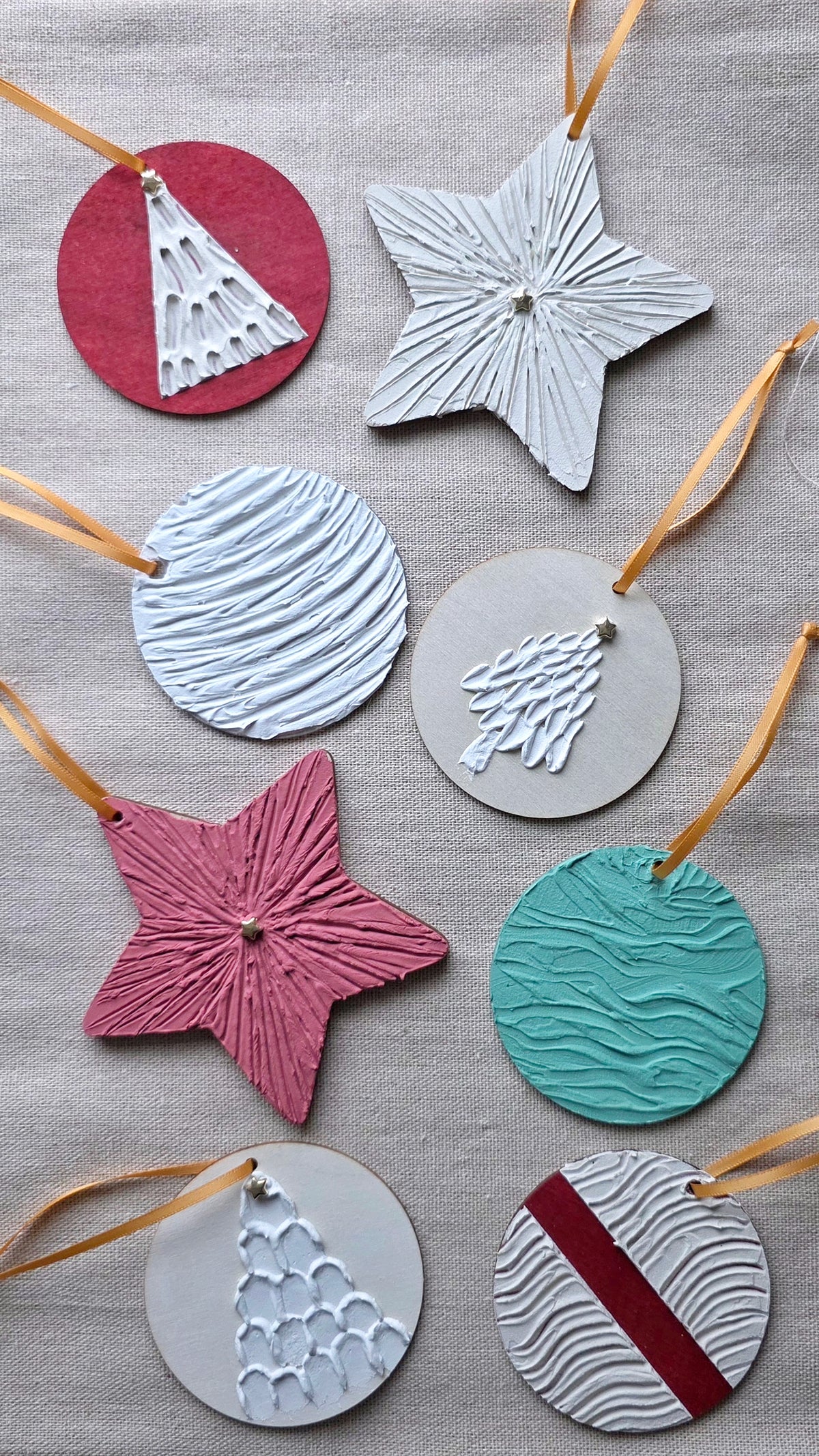 Handmade textured plaster ornaments in star and round shapes with gold ribbon